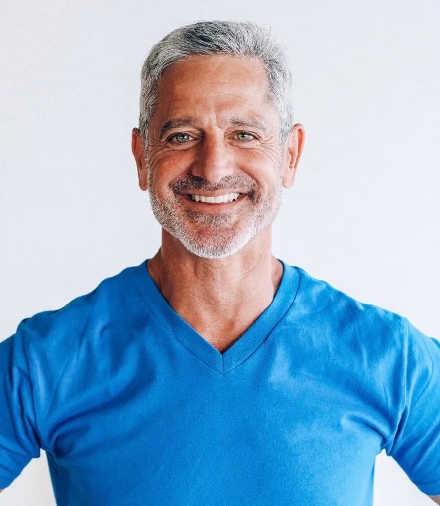 Steven Klein smiling in a bright blue tee